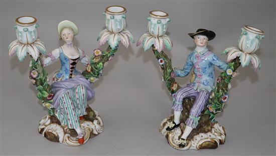 A pair of Meissen figural candelabra, late 19th century, height 19.5cm, typical minor losses to flowers, replacement nozzles